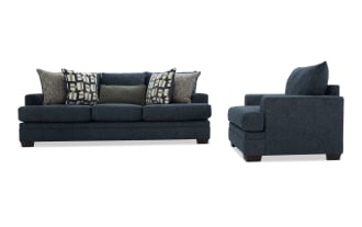 Dark blue fabric sofa with plush cushions and patterned throw pillows, featuring a modern, boxy design and wooden legs, shown from front and side angles.