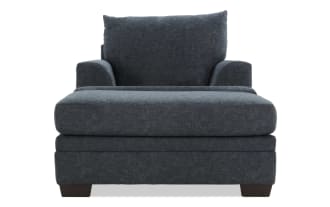 Dark gray upholstered armchair with plush cushions, wide seat, and low wooden legs, ideal for modern living room seating.