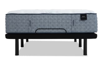 Mattress labeled "ENVY WELCOME TO BED" with a textured gray fabric side panel, white quilted top, and black metal bed frame with cylindrical legs.
