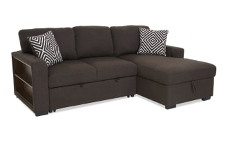 Brown fabric sectional sofa with chaise lounge, featuring two black and white geometric patterned throw pillows, modern design.
