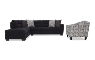 Black sectional sofa with tufted back cushions, fabric upholstery, and patterned throw pillows, paired with a gray and white patterned fabric armchair.