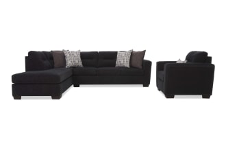 Dark charcoal gray fabric sectional sofa with chaise lounge and matching armchair, featuring tufted cushions and patterned throw pillows for modern living rooms.