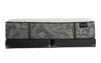 Zeus mattress with gray patterned fabric and white quilted top, placed on black Bob's bed foundation, showcasing modern bedding design.