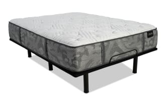 Queen-sized Zeus mattress with gray patterned fabric sides and white quilted top, supported by a black metal bed frame with legs.