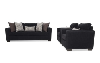Black fabric living room sofa set with a three-seat couch and two armchairs, featuring plush cushions and patterned throw pillows.