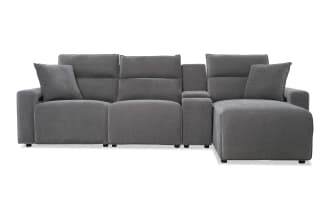 Modern sectional sofa in dark gray fabric upholstery with adjustable headrests, plush cushions, and a built-in center console for living room comfort.