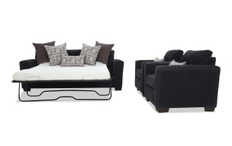 Dark gray fabric sleeper sofa with metal frame mattress pulled out, accompanied by matching armchairs with patterned throw pillows, modern style.