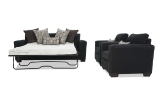 Dark gray fabric sofa bed with metal frame pull-out mattress and multiple patterned and solid throw pillows, paired with two matching armchairs.