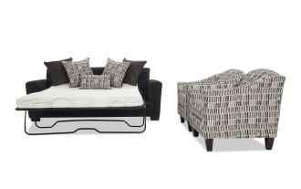 Black fabric sofa bed with metal frame and white mattress, accompanied by patterned beige and gray accent chairs with wooden legs.