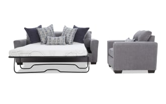 Gray fabric sleeper sofa bed with metal frame mattress pulled out, featuring multiple decorative blue and gray patterned cushions, shown from front and side angles.