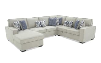 Light gray fabric sectional sofa with chaise lounge, featuring plush cushions and blue patterned throw pillows, modern style seating.