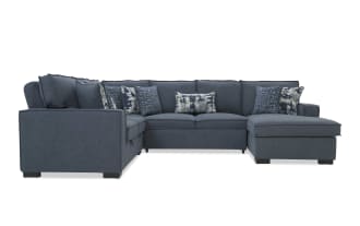 Dark blue fabric sectional sofa with chaise, featuring multiple patterned throw pillows and plush cushions, ideal for modern living rooms.