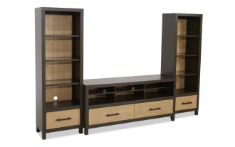 Modern entertainment center with dark brown frame and light wood paneling, featuring open shelves, drawers, and cable management holes for TV and media storage.