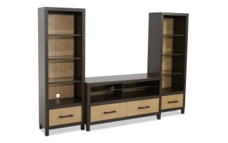 Modern entertainment center with dark brown wood frame and light wood paneling, featuring open shelves, drawers, and cable management holes.