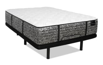 Mattress with a gray and white floral-patterned fabric, black base with metal legs, and a label reading "DISTINCTION" on the side.