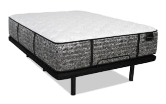 Mattress with a white quilted top and gray floral patterned sides on a black metal bed frame with legs, labeled "DISTINCTION."