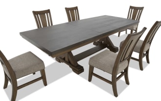 Extendable rectangular wooden dining table with a dark finish and six matching chairs featuring beige upholstered seats and slatted backs.