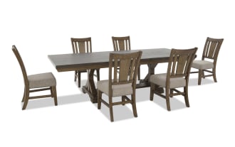 Extendable rectangular wooden dining table with a dark finish and six matching chairs featuring beige upholstered seats and slatted backs.