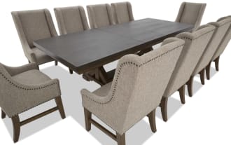 Dining set with a rectangular dark wood table and ten beige upholstered chairs featuring nailhead trim and wooden legs, suitable for large gatherings.