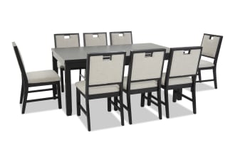 Modern black wooden dining table set with eight beige upholstered chairs, featuring cushioned seats and backrests, ideal for contemporary dining rooms.