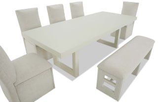 Modern dining set with a rectangular white wooden table, six beige upholstered chairs, and a matching cushioned bench, ideal for contemporary interiors.