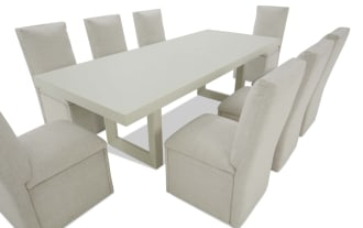 Modern dining set with a white rectangular table and eight beige upholstered fabric chairs, featuring clean lines and a minimalist design.