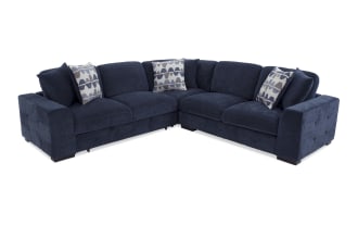 Dark blue fabric sectional sofa with tufted armrests, cushioned seats, and geometric patterned throw pillows, designed for modern living rooms.