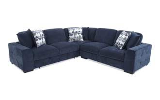 Navy blue fabric sectional sofa with plush cushions, tufted armrests, and three patterned throw pillows, designed for modern living rooms.