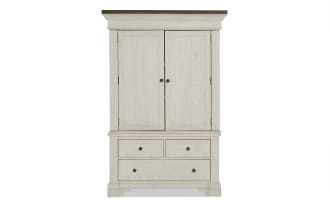 Whitewashed wooden armoire with two doors, two small drawers, and one large drawer, featuring black round knobs and a classic design.