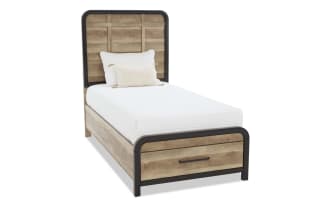 Twin bed with rustic wood panel headboard and footboard, black metal frame, white mattress, and decorative white pillows.