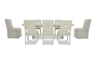 Modern dining table set with a rectangular white table and eight beige upholstered chairs featuring square cutout backrests and cushioned seats.