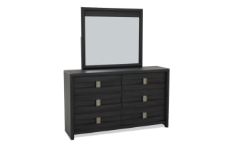 Black wooden dresser with six drawers and a rectangular mirror on top, featuring modern metal handles and a sleek, contemporary design.