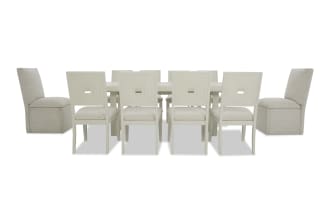 Modern dining set with a rectangular white table, six white wooden chairs with square cutout backs, and two beige upholstered end chairs.