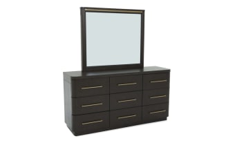 Dark wood dresser with nine drawers and brass handles, featuring a large rectangular mirror with matching brass trim, modern bedroom furniture.