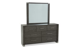 Dark wood dresser with six drawers and three smaller top drawers, featuring sleek metal handles and a matching framed mirror, modern bedroom furniture.