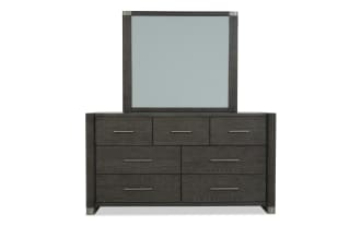 Dark wood dresser with six drawers and three smaller top drawers, featuring sleek metal handles and a matching framed mirror, modern bedroom furniture.
