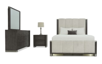 Modern bedroom set featuring a dark wood dresser with mirror, matching nightstand with lamp, and a beige upholstered bed with padded headboard and footboard.