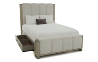 Modern bedroom set featuring a beige upholstered bed with vertical channel tufting, wooden frame, matching wood dresser with mirror, nightstand, and chest of drawers in a light brown finish.