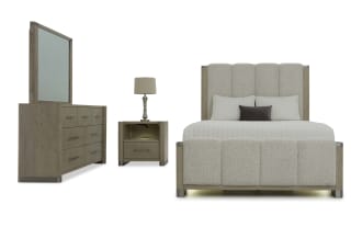 Modern bedroom set featuring a beige upholstered bed with vertical panel design, matching wood nightstand with drawer, and a wood dresser with large mirror.