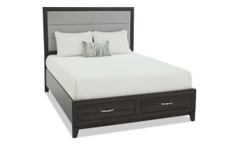 King-size bed with dark wood frame, gray upholstered panel headboard, white bedding, and two storage drawers with metal handles.