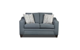 Blue fabric loveseat sofa with two patterned beige and blue throw pillows, featuring modern square arms and dark wooden legs.