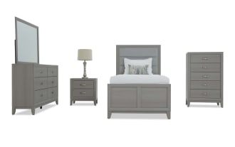 Gray wood bedroom set with upholstered headboard, includes dresser with mirror, nightstand with lamp, bed, and tall chest of drawers.