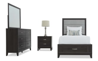Dark wood bedroom set with a dresser and mirror, two-drawer nightstand with silver lamp, and a twin bed featuring a gray upholstered headboard and storage drawer.