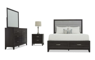 Dark wood bedroom set featuring a king-size bed with upholstered gray headboard, two storage drawers, matching nightstand with lamp, and six-drawer dresser with mirror.