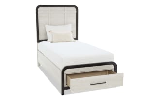 Modern bedroom set with light wood finish and dark brown trim, featuring a dresser with mirror, two-drawer nightstand with lamp, and a twin bed with headboard and footboard.