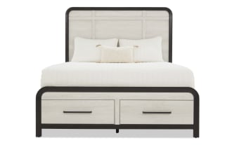 King-size bed with light wood panel headboard and footboard, black metal frame, two storage drawers, and white bedding with pillows.