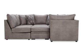 Modern L-shaped sectional sofa in soft gray microfiber fabric with plush cushions and two patterned accent pillows, ideal for contemporary living rooms.