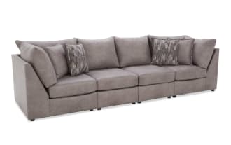 Modern gray fabric sectional sofa with plush cushions and patterned throw pillows, featuring a sleek, low-profile design ideal for contemporary living rooms.