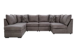 Large L-shaped sectional sofa in gray microfiber fabric with plush cushions and patterned accent pillows, designed for modern living rooms.