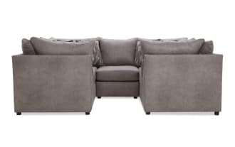 Modern U-shaped sectional sofa in taupe microfiber fabric with plush back cushions and patterned accent pillows, ideal for spacious living rooms.